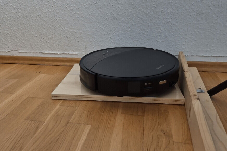 Roborock Saros 10R klettert mit angehobenem Chassis über eine hohe Türschwelle